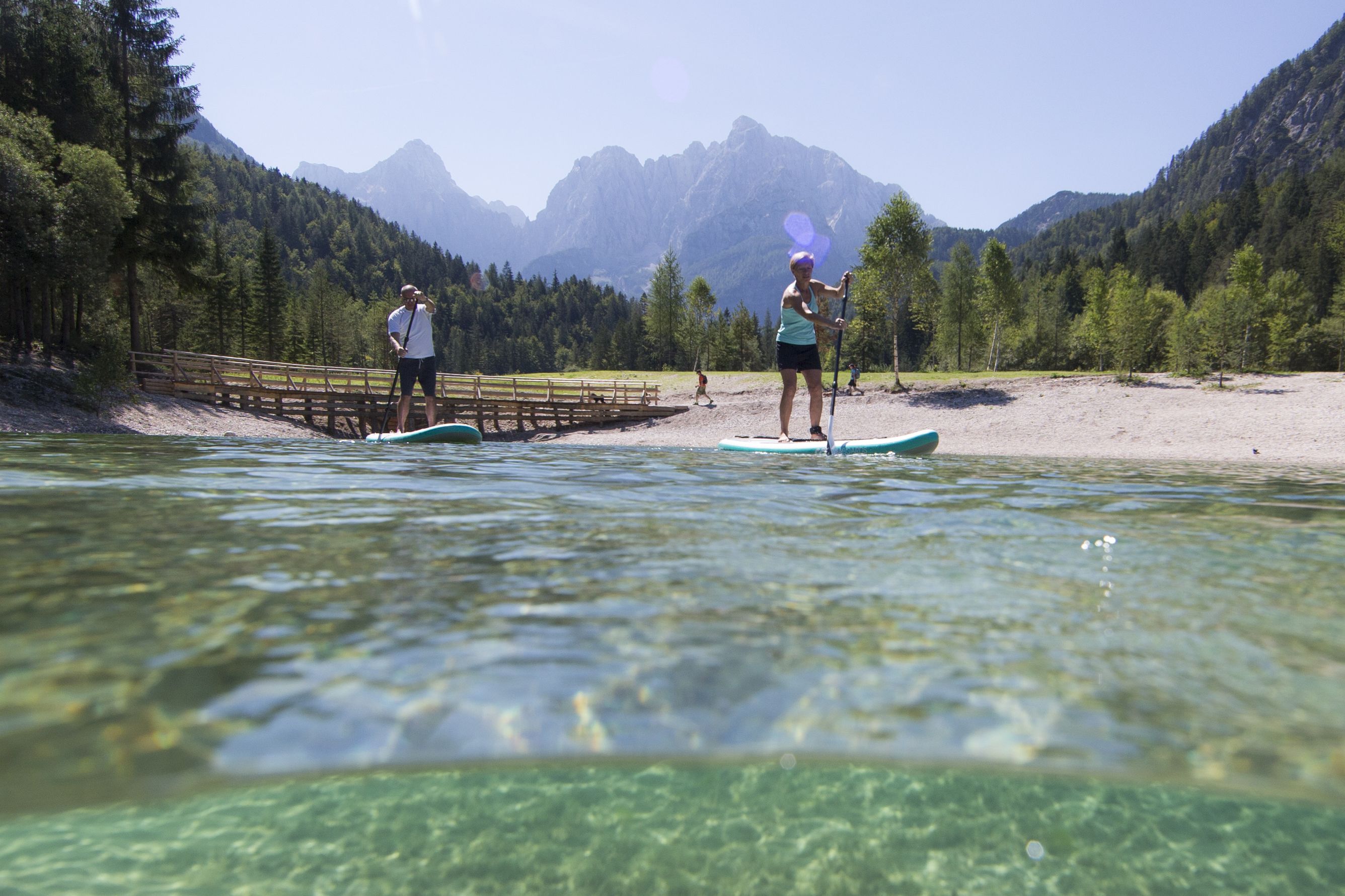 Ein Paar startet ihre SipaBoard e-SUP Tour vor eine Brücke